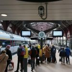 a group of people waiting for a train at a train station